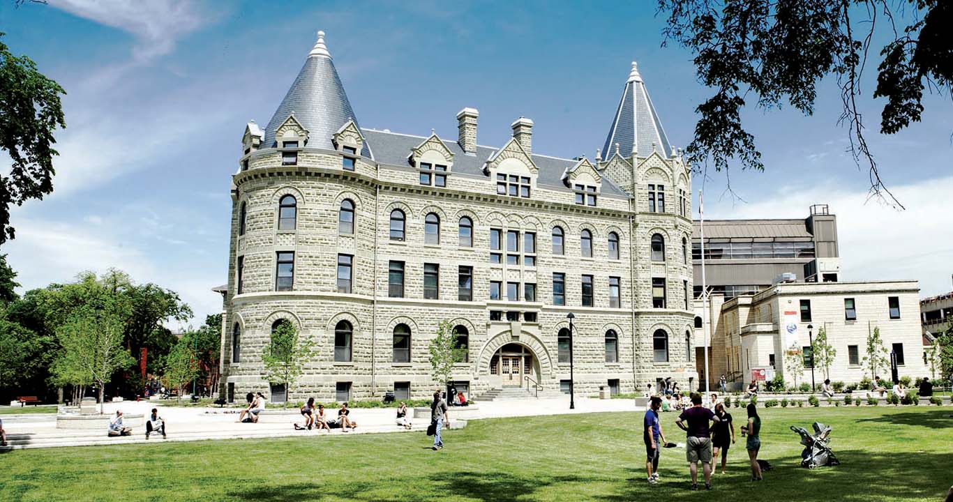 large building with field and people walking around