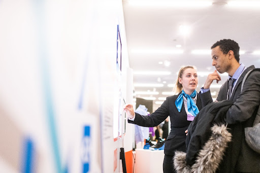 Recruiter and candidate speaking at a physical job fair