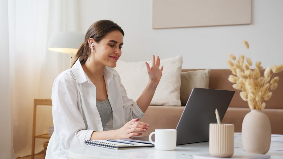 woman waving to her virtual meeting